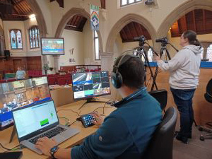 Video equipment and monitors set up and recording at the front of the church.